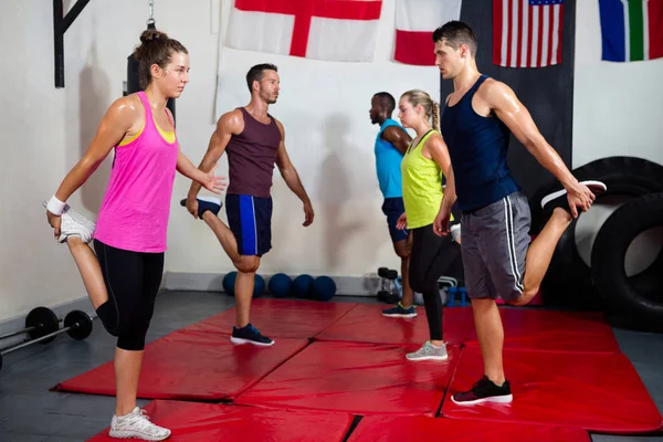 Young athletes stretching legs — Stock Photo, Image