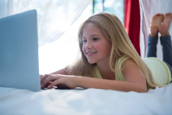 Meisje met laptop op bed — Stockfoto