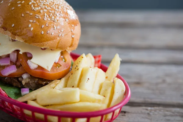 Batatas fritas e cheeseburger na cesta — Fotografia de Stock