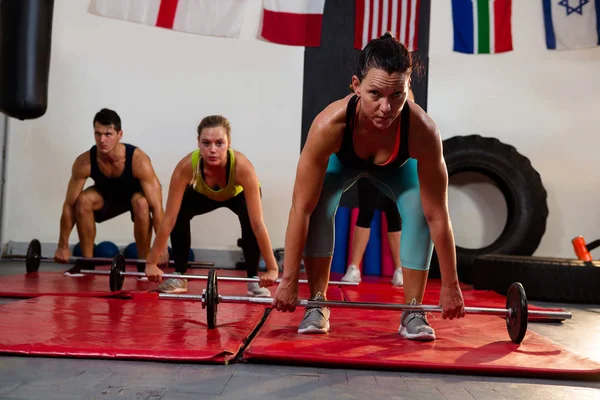 Atleta levantando barra con amigos —  Fotos de Stock