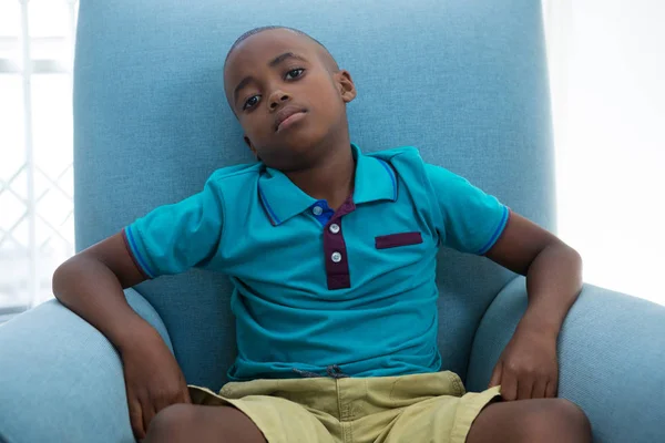 Niño sentado en sillón azul —  Fotos de Stock