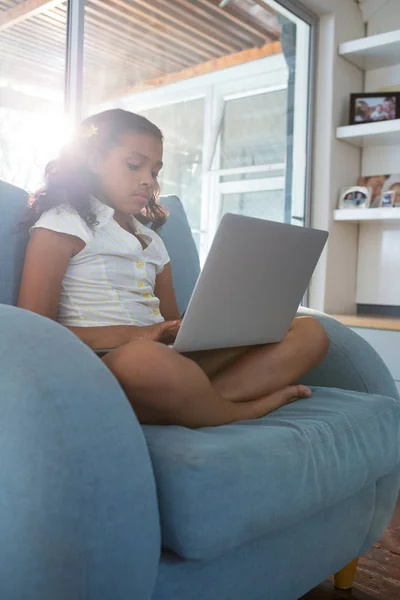 Chica usando el ordenador portátil en sillón — Foto de Stock