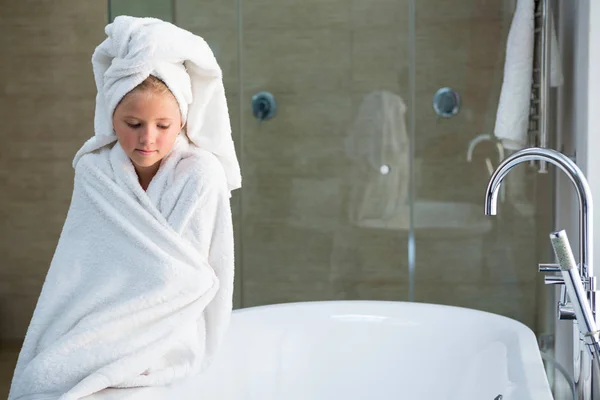 Girl wrapped in towel sitting on bathtub — Stock Photo, Image