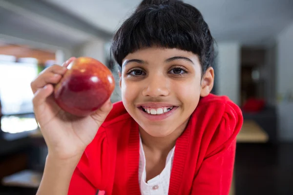 Улыбающаяся девушка держит свежее яблоко — стоковое фото