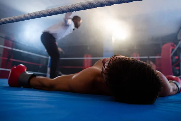 ボクサーはリングにレフェリーの近くに横たわって — ストック写真