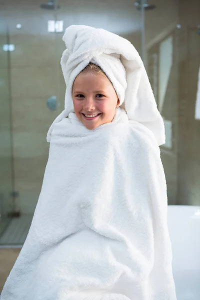 Ragazza avvolta in asciugamano seduto sulla vasca da bagno — Foto Stock