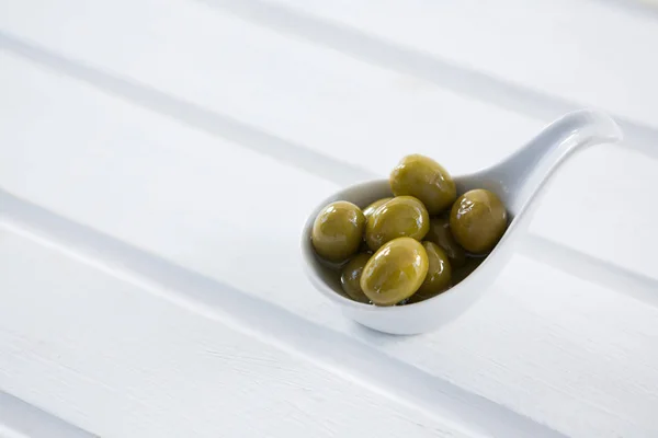 Marinated green olives in spoon — Stock Photo, Image