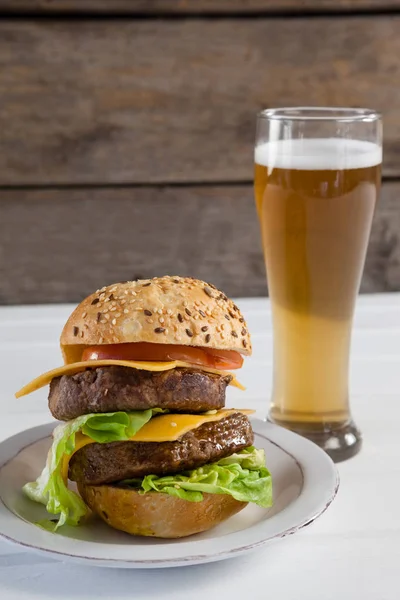 Hamburguesa en plato y vaso de cerveza — Foto de Stock