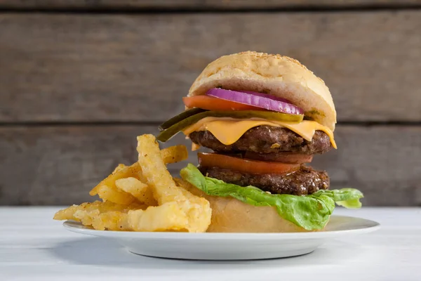 Hambúrguer e batatas fritas em prato — Fotografia de Stock