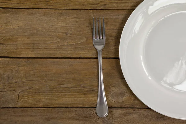 Белая тарелка и вилка — стоковое фото