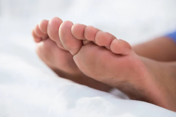 Girls feet on bed — Stock Photo, Image