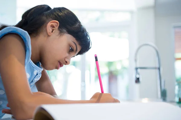 Girl writing in book — Stock Photo, Image