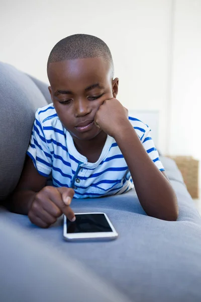 Jongen met behulp van mobiele telefoon op Bank — Stockfoto