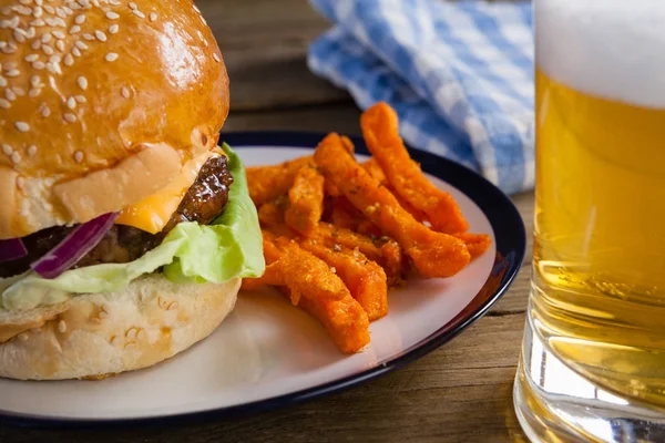 Hamburguesa y papas fritas con vaso de cerveza — Foto de Stock