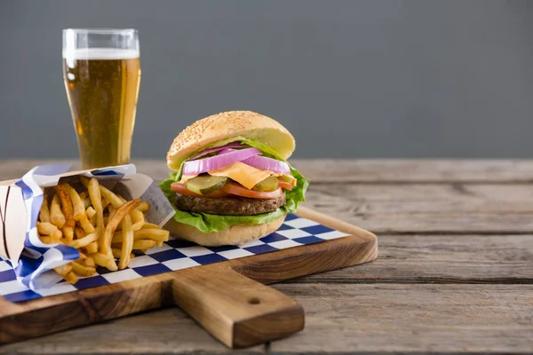 Burger z frytkami i szklankę piwa — Zdjęcie stockowe