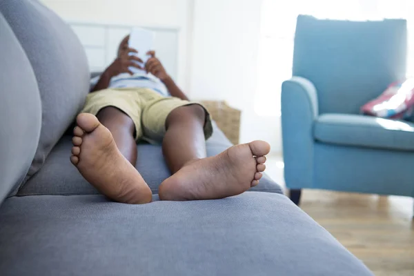 Niño acostado en el sofá y el uso de teléfono —  Fotos de Stock