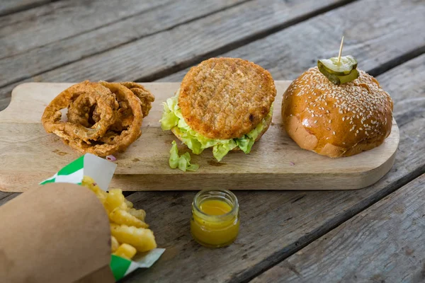 Hambúrguer e batatas fritas com anéis de cebola — Fotografia de Stock