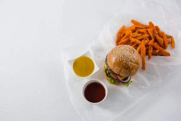 Hambúrguer e batatas fritas com molhos — Fotografia de Stock