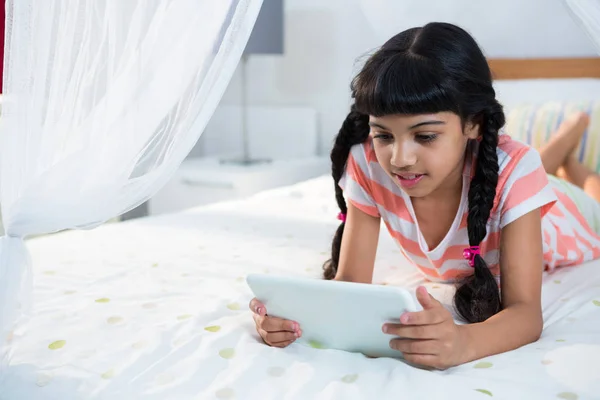 Ragazza utilizzando tablet sul letto — Foto Stock