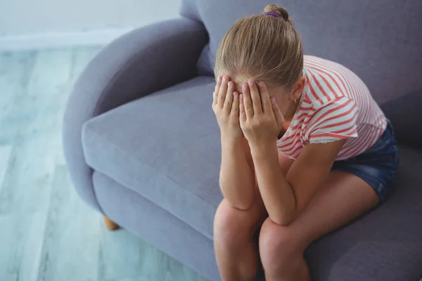 Meisje zit met handen die betrekking hebben op gezicht — Stockfoto