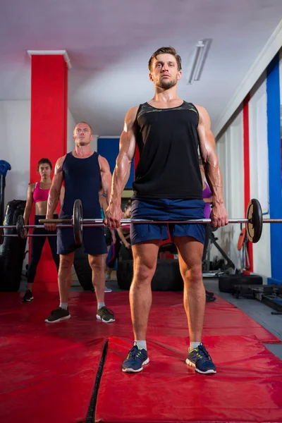 Athletes lifting barbells on exercise mats — Stock Photo, Image