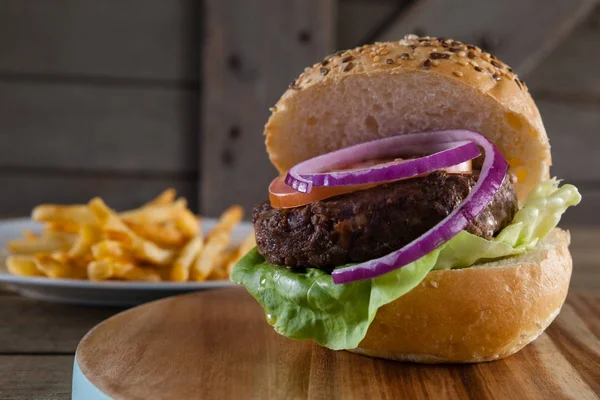 Hamburguesa sobre tabla de cortar — Foto de Stock