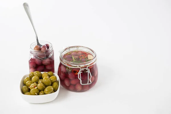 Pickled olives in jars and bowl — Stock Photo, Image