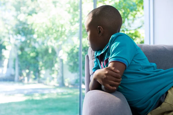 Nadenkende jongen op zoek door raam — Stockfoto