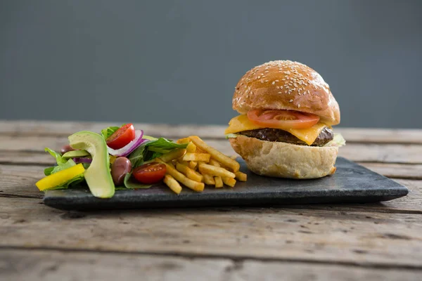 Salad with french fries and burger — Stock Photo, Image