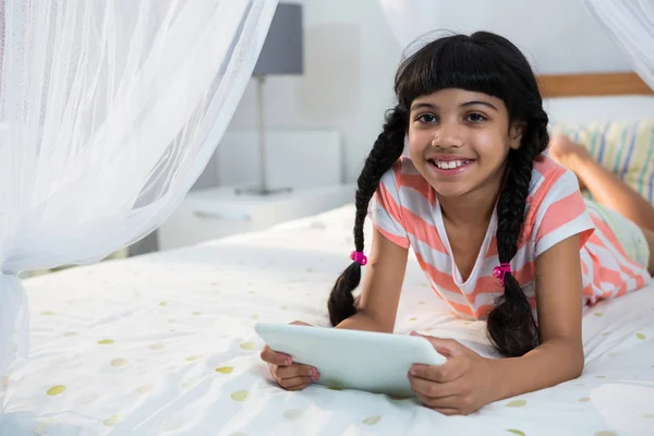 Κορίτσι χρησιμοποιώντας ψηφιακή δισκίο σε κρεβάτι — Φωτογραφία Αρχείου