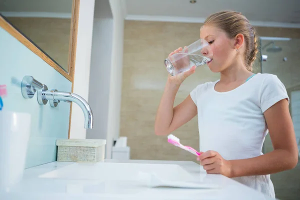 Fille eau potable dans la salle de bain — Photo