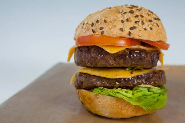 Leckerer Hamburger auf braunem Papier — Stockfoto