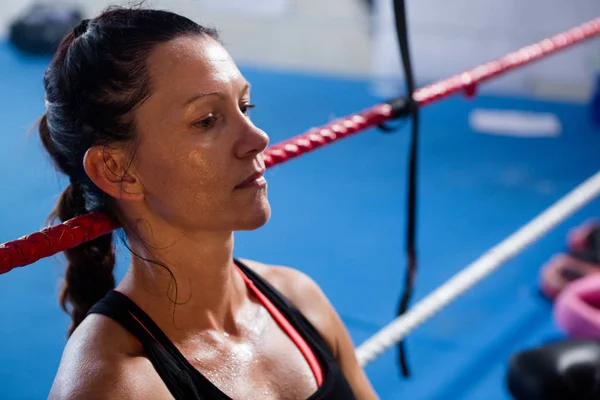 Thoughtful female boxer leaning on rope — Stock Photo, Image