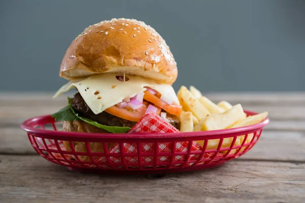 Hamburguesa con queso y papas fritas en cesta — Foto de Stock