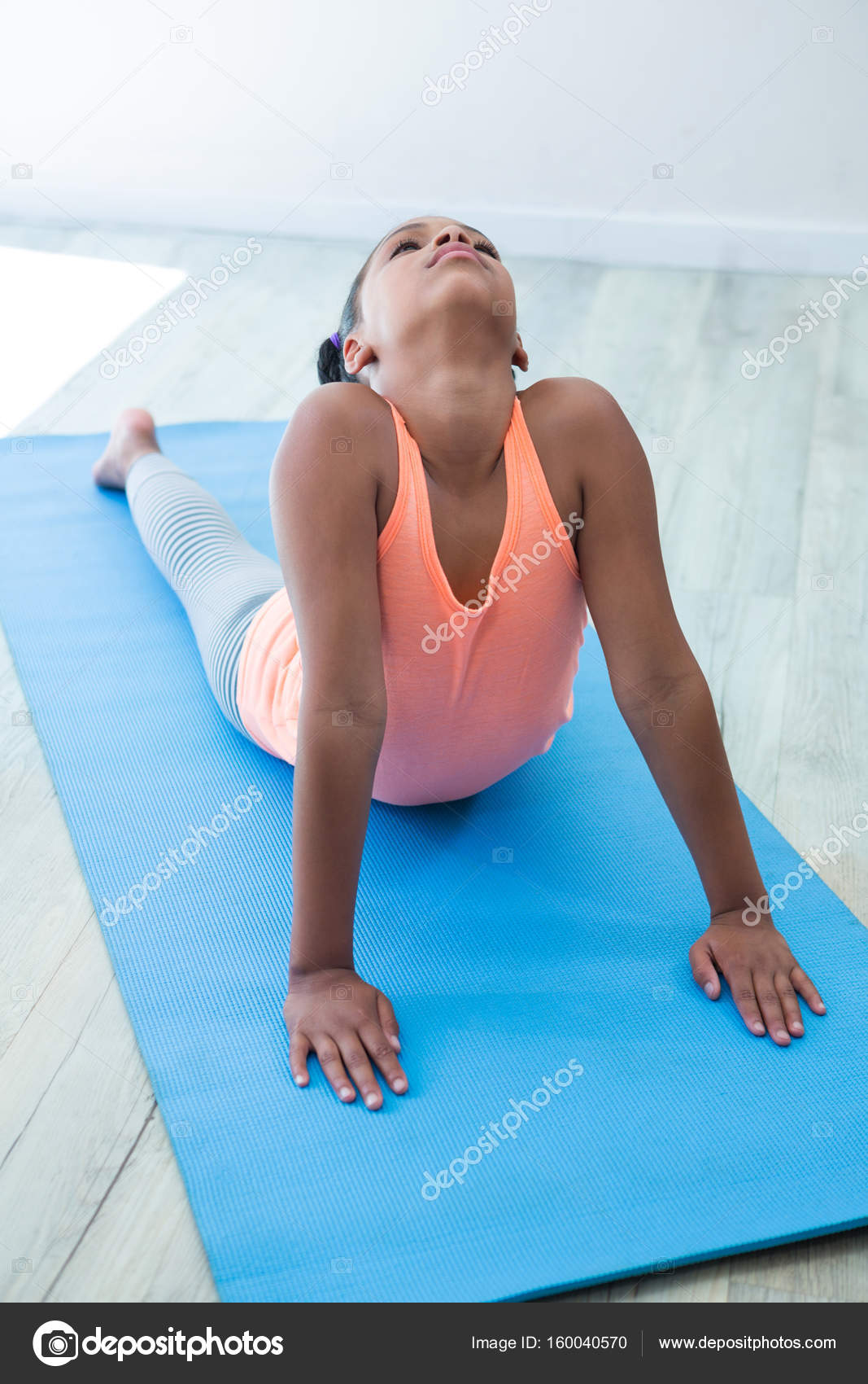 girl-doing-dog-pose-stock-photo-by-wavebreakmedia-160040570