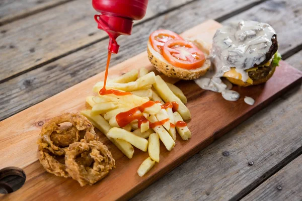 Ketchup Frasco derramando molho em batatas fritas — Fotografia de Stock