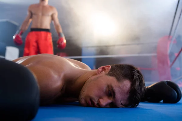 リングに横たわって意識不明の男性ボクサー — ストック写真