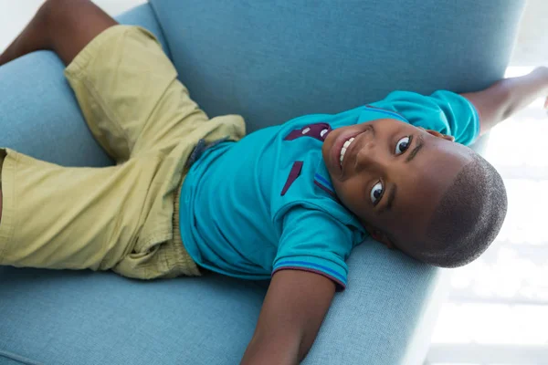 Niño acostado en sillón azul —  Fotos de Stock