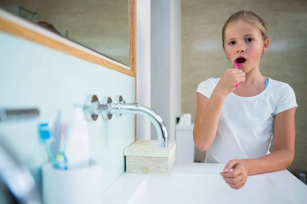 Girl brushing teeth in bathroom — Stock Photo, Image
