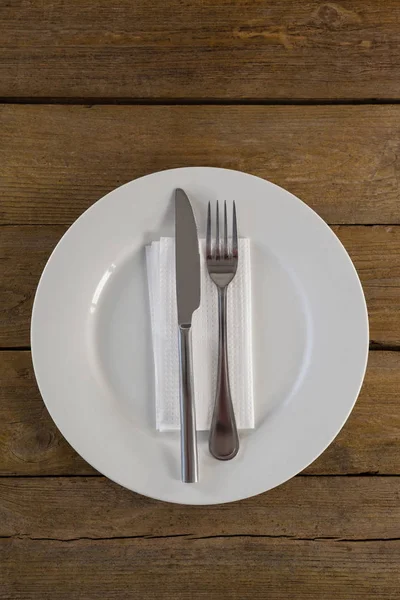 Placa branca com talheres e guardanapo na mesa — Fotografia de Stock