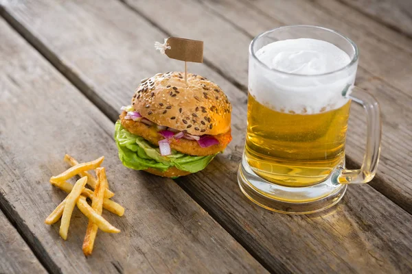 Batatas fritas com hambúrguer e copo de cerveja — Fotografia de Stock