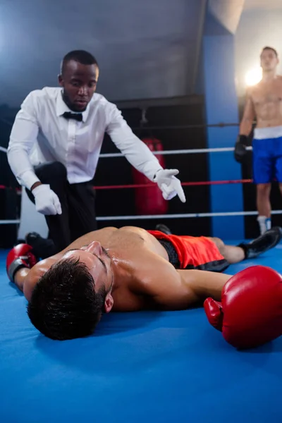 Referee counting near athlete — Stock Photo, Image