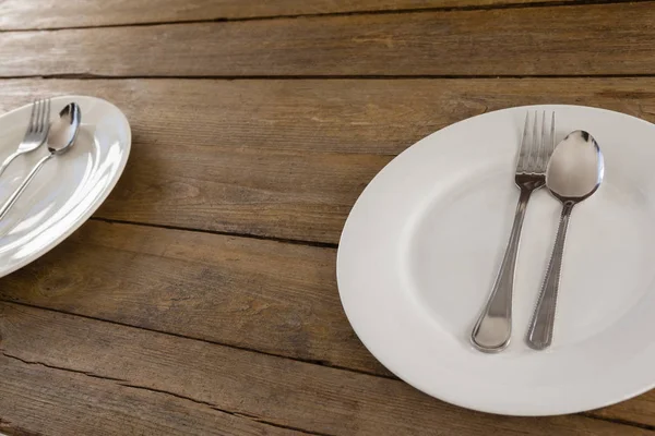 Белая тарелка с столовыми приборами — стоковое фото