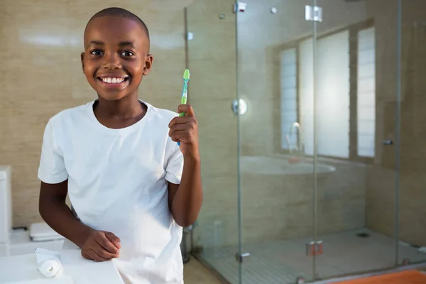 Sorrindo menino segurando escova de dentes — Fotografia de Stock