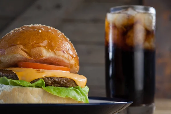 Hamburguesa en plato con vaso de bebida fría — Foto de Stock