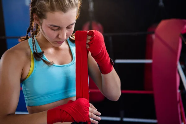 Female athlete wrapping bandage on hand — Stock Photo, Image