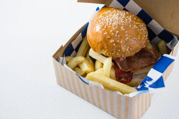 Hambúrguer e batatas fritas na caixa — Fotografia de Stock