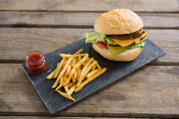 Cheeseburger com batatas fritas e molho — Fotografia de Stock