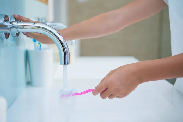 Girl washing toothbrush — Stock Photo, Image