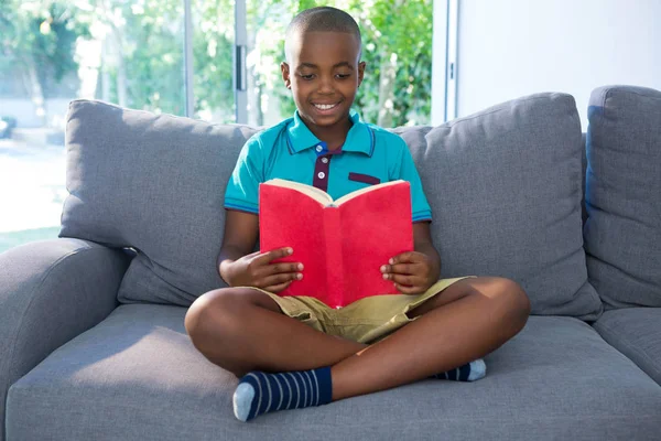 Junge liest Roman auf Sofa — Stockfoto